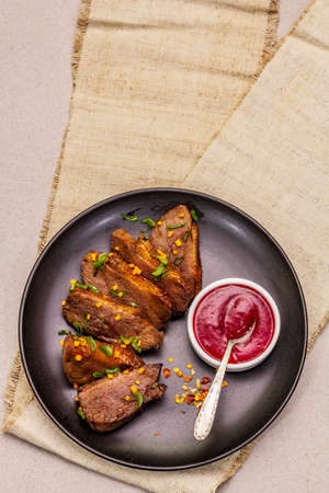 Roast and braised duck breast with sweet and sour berry sauce. Traditional French food, stone concrete backgroundの写真素材