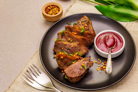 Roast and braised duck breast with sweet and sour berry sauce. Traditional French food, stone concrete backgroundの写真素材