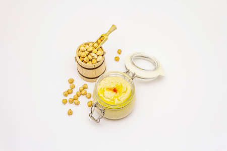Hummus isolated on white background. Dry chickpea in wooden barrel. Traditional food in Middle Eastern and Mediterranean cuisineの写真素材