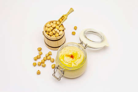 Hummus isolated on white background. Dry chickpea in wooden barrel. Traditional food in Middle Eastern and Mediterranean cuisineの写真素材