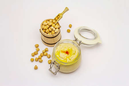Hummus isolated on white background. Dry chickpea in wooden barrel. Traditional food in Middle Eastern and Mediterranean cuisineの写真素材