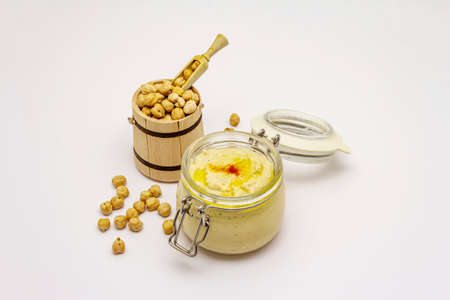Hummus isolated on white background. Dry chickpea in wooden barrel. Traditional food in Middle Eastern and Mediterranean cuisineの写真素材