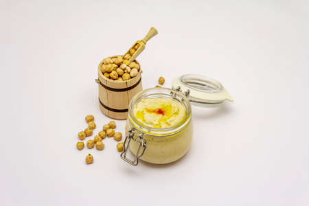 Hummus isolated on white background. Dry chickpea in wooden barrel. Traditional food in Middle Eastern and Mediterranean cuisineの写真素材