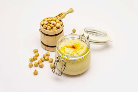 Hummus isolated on white background. Dry chickpea in wooden barrel. Traditional food in Middle Eastern and Mediterranean cuisineの写真素材