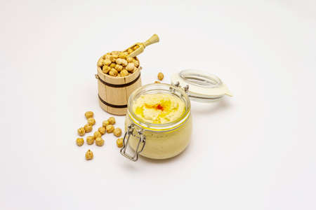 Hummus isolated on white background. Dry chickpea in wooden barrel. Traditional food in Middle Eastern and Mediterranean cuisineの写真素材