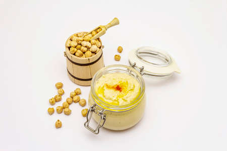 Hummus isolated on white background. Dry chickpea in wooden barrel. Traditional food in Middle Eastern and Mediterranean cuisineの写真素材