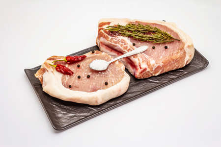 Raw pork steaks isolated on white background. Spices, sea salt, rosemary, chili pepperの写真素材