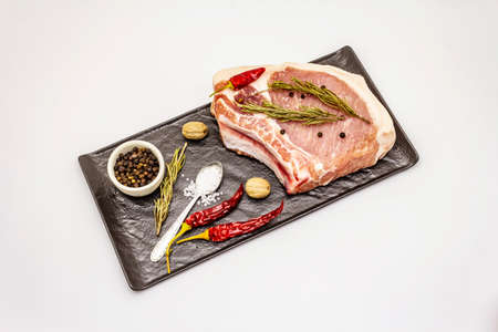Raw pork steak isolated on white background. Spices, sea salt, rosemary, chili pepperの写真素材