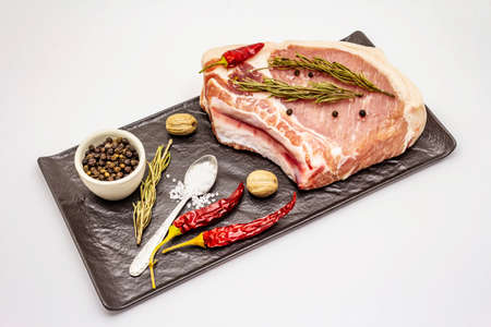 Raw pork steak isolated on white background. Spices, sea salt, rosemary, chili pepperの写真素材