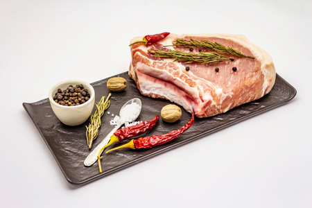 Raw pork steak isolated on white background. Spices, sea salt, rosemary, chili pepperの写真素材