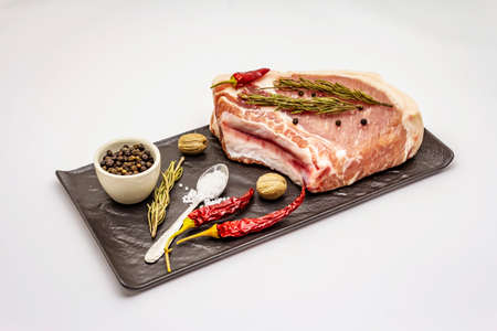 Raw pork steak isolated on white background. Spices, sea salt, rosemary, chili pepperの写真素材