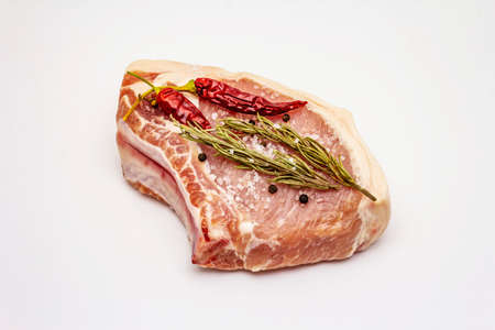 Raw pork steak isolated on white background. Spices, sea salt, rosemary, chili pepperの写真素材