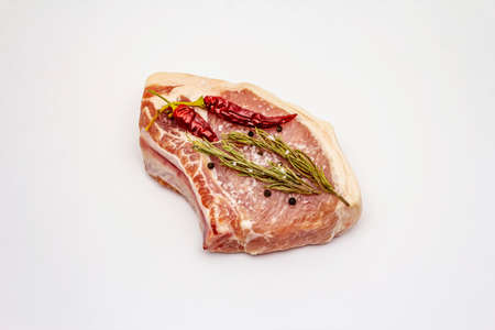 Raw pork steak isolated on white background. Spices, sea salt, rosemary, chili pepperの写真素材
