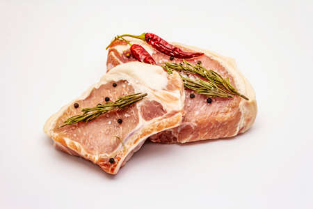 Raw pork steaks isolated on white background. Spices, sea salt, rosemary, chili pepperの写真素材