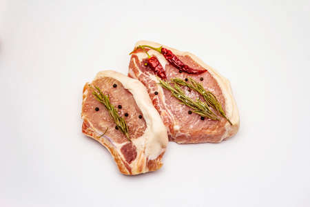 Raw pork steaks isolated on white background. Spices, sea salt, rosemary, chili pepperの写真素材