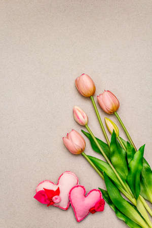 Greetings card, wallpaper, backdrop. Happy Mothers Day, St.Valentines or Wedding. Gentle pink tulips, handmade felt hearts. Stone concrete backgroundの写真素材