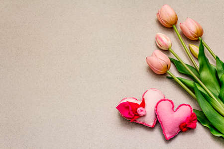Greetings card, wallpaper, backdrop. Happy Mothers Day, St.Valentines or Wedding. Gentle pink tulips, handmade felt hearts. Stone concrete backgroundの写真素材