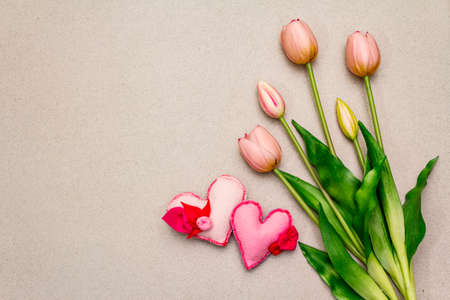 Greetings card, wallpaper, backdrop. Happy Mothers Day, St.Valentines or Wedding. Gentle pink tulips, handmade felt hearts. Stone concrete backgroundの写真素材