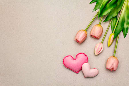 Greetings card, wallpaper, backdrop. Happy Mothers Day, St.Valentines or Wedding. Gentle pink tulips, handmade felt hearts. Stone concrete backgroundの写真素材