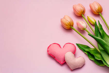 Greetings card, wallpaper, backdrop. Happy Mothers Day, Easter, St.Valentines or Wedding. Gentle pink tulips, handmade felt hearts on rosy backgroundの写真素材