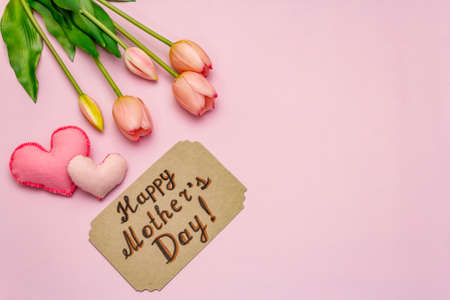 Greetings card for Happy Mothers Day. Gentle pink tulips, handmade felt hearts on rosy backgroundの写真素材