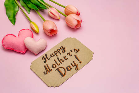 Greetings card for Happy Mothers Day. Gentle pink tulips, handmade felt hearts on rosy backgroundの写真素材