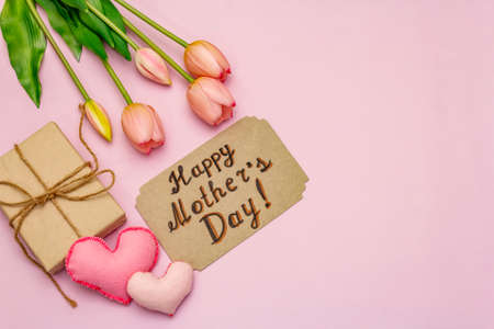 Greetings card for Happy Mothers Day. Gentle pink tulips, handmade felt hearts, zero waste packaging gift on rosy backgroundの写真素材