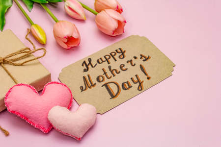 Greetings card for Happy Mothers Day. Gentle pink tulips, handmade felt hearts, zero waste packaging gift on rosy backgroundの写真素材