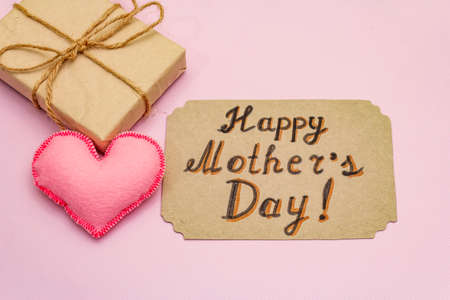 Greetings card for Happy Mothers Day. Label, handmade felt hearts, zero waste packaging gift on rosy backgroundの写真素材