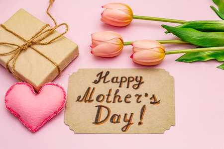 Greetings card for Happy Mothers Day. Gentle pink tulips, handmade felt hearts, zero waste packaging gift on rosy backgroundの写真素材