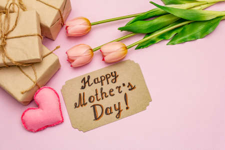 Greetings card for Happy Mothers Day. Gentle pink tulips, handmade felt hearts, zero waste packaging gift on rosy backgroundの写真素材