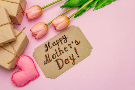 Greetings card for Happy Mothers Day. Gentle pink tulips, handmade felt hearts, zero waste packaging gift on rosy backgroundの写真素材