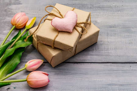 Greetings card, wallpaper, backdrop. Happy Mothers Day, St.Valentines or Wedding. Gentle pink tulips, handmade felt heart, zero waste packaging gift. Wooden boards backgroundの写真素材