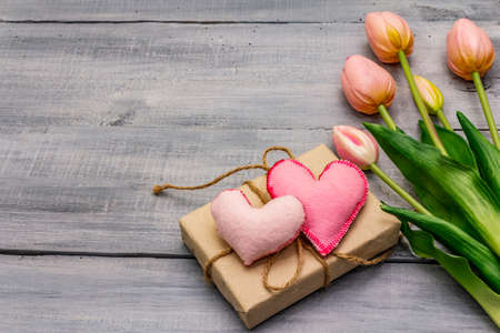 Greetings card, wallpaper, backdrop. Happy Mothers Day, St.Valentines or Wedding. Gentle pink tulips, handmade felt heart, zero waste packaging gift. Wooden boards backgroundの写真素材