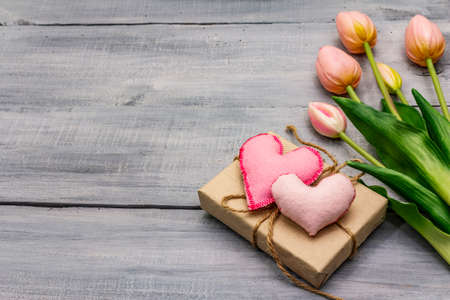 Greetings card, wallpaper, backdrop. Happy Mothers Day, St.Valentines or Wedding. Gentle pink tulips, handmade felt heart, zero waste packaging gift. Wooden boards backgroundの写真素材