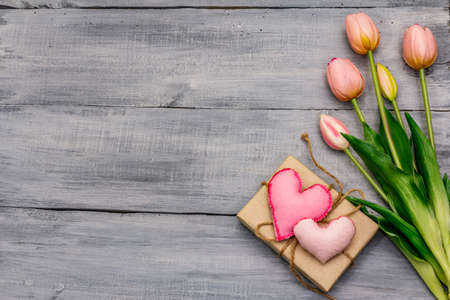 Greetings card, wallpaper, backdrop. Happy Mothers Day, St.Valentines or Wedding. Gentle pink tulips, handmade felt heart, zero waste packaging gift. Wooden boards backgroundの写真素材