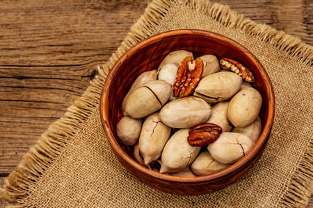 Ripe pecan on vintage wooden background. Traditional ingredient for pecan pie in USAの写真素材