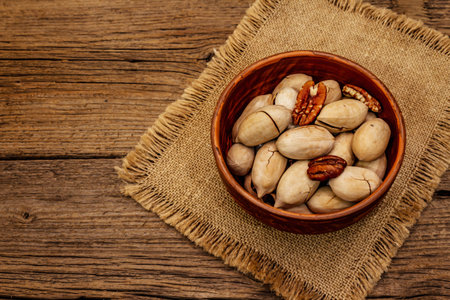 Ripe pecan on vintage wooden background. Traditional ingredient for pecan pie in USA
