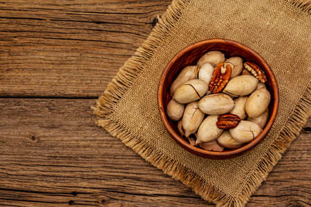Ripe pecan on vintage wooden background. Traditional ingredient for pecan pie in USAの写真素材