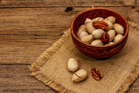 Ripe pecan on vintage wooden background. Traditional ingredient for pecan pie in USAの写真素材