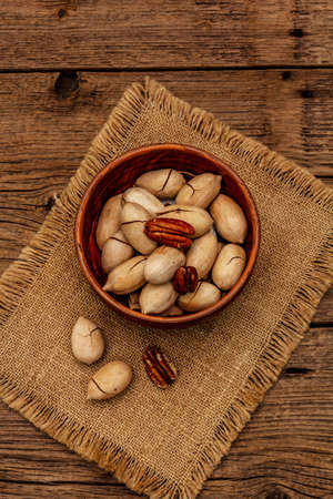 Ripe pecan on vintage wooden background. Traditional ingredient for pecan pie in USAの写真素材