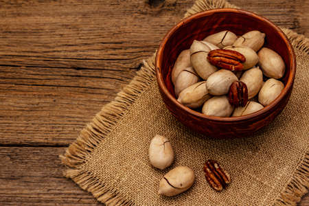 Ripe pecan on vintage wooden background. Traditional ingredient for pecan pie in USAの写真素材