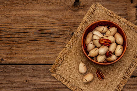 Ripe pecan on vintage wooden background. Traditional ingredient for pecan pie in USAの写真素材
