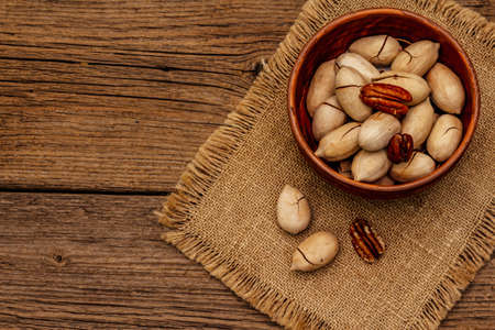 Ripe pecan on vintage wooden background. Traditional ingredient for pecan pie in USAの写真素材