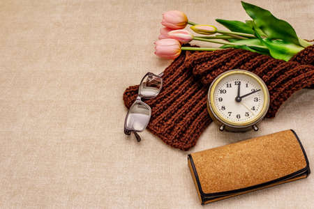 Happy Grandparents Day. Bouquet of gentle rosy tulip, warm knitted scarf, glasses and alarm clock, copy spaceの写真素材