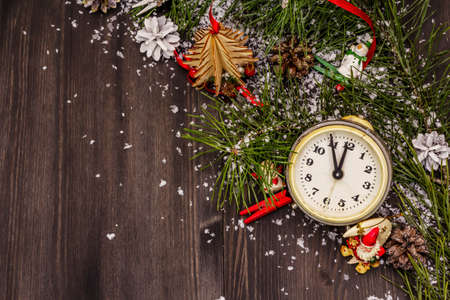 Five minutes to midnight. New Year concept. Alarm clock, pine branch, Christmas decorations. Black boards background, top viewの写真素材