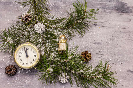 Few minutes to midnight. New Year concept. Alarm clock, pine branch, Christmas decorations. Grey stone concrete backgroundの写真素材