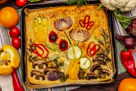 Colorful Garden Focaccia. Fresh ripe vegetables, olive oil, greens. Traditional Italian bakery. Old wooden boards backgroundの写真素材