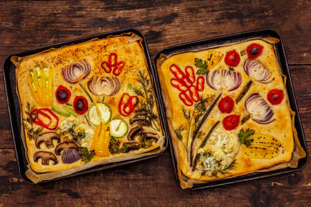 Colorful Garden Focaccia. Fresh ripe vegetables, olive oil, greens. Traditional Italian bakery. Old wooden boards backgroundの写真素材