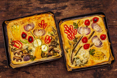 Colorful Garden Focaccia. Fresh ripe vegetables, olive oil, greens. Traditional Italian bakery. Old wooden boards backgroundの写真素材